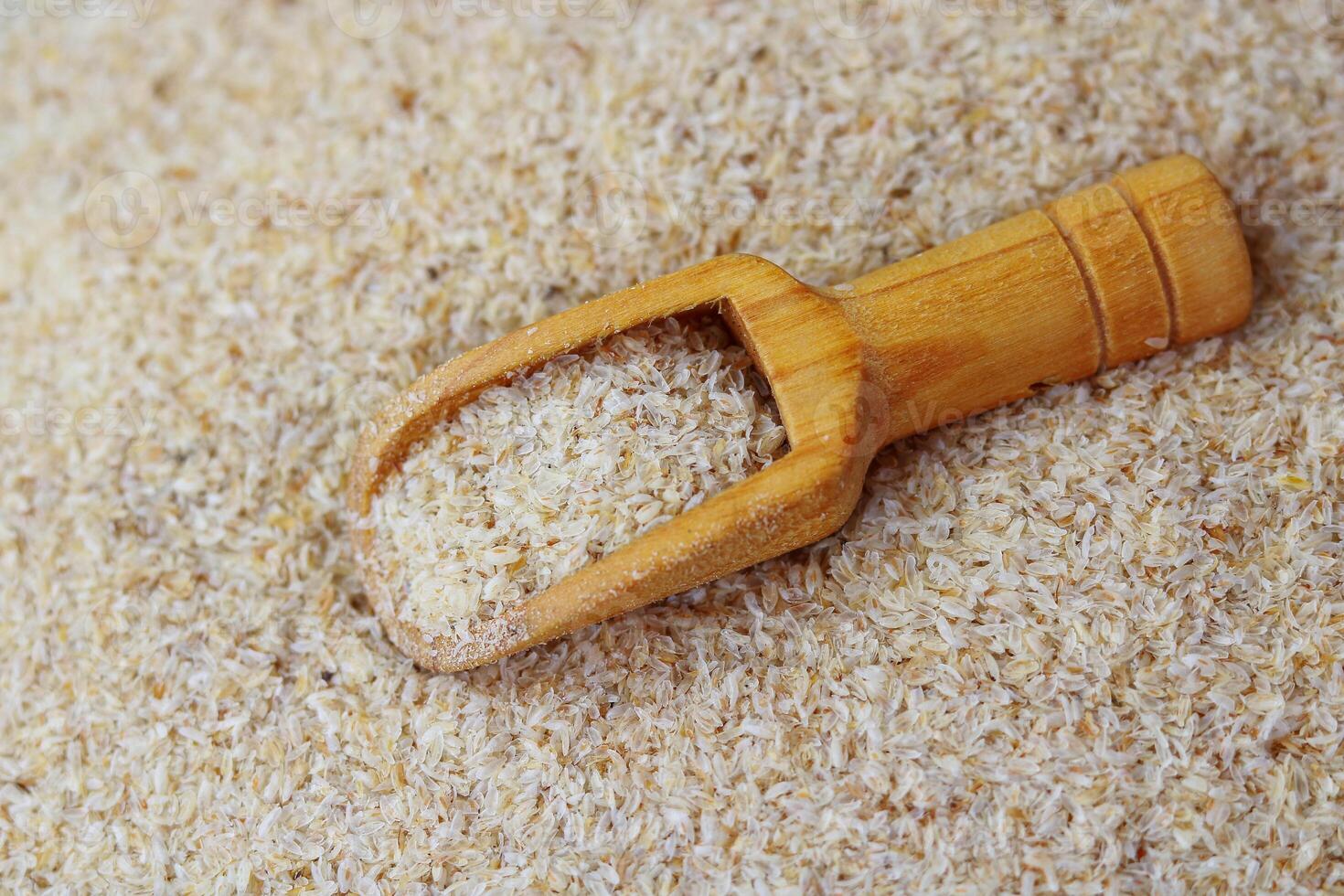 Wooden scoop with Psyllium Husk Isabgol on the background of Psyllium Husk photo