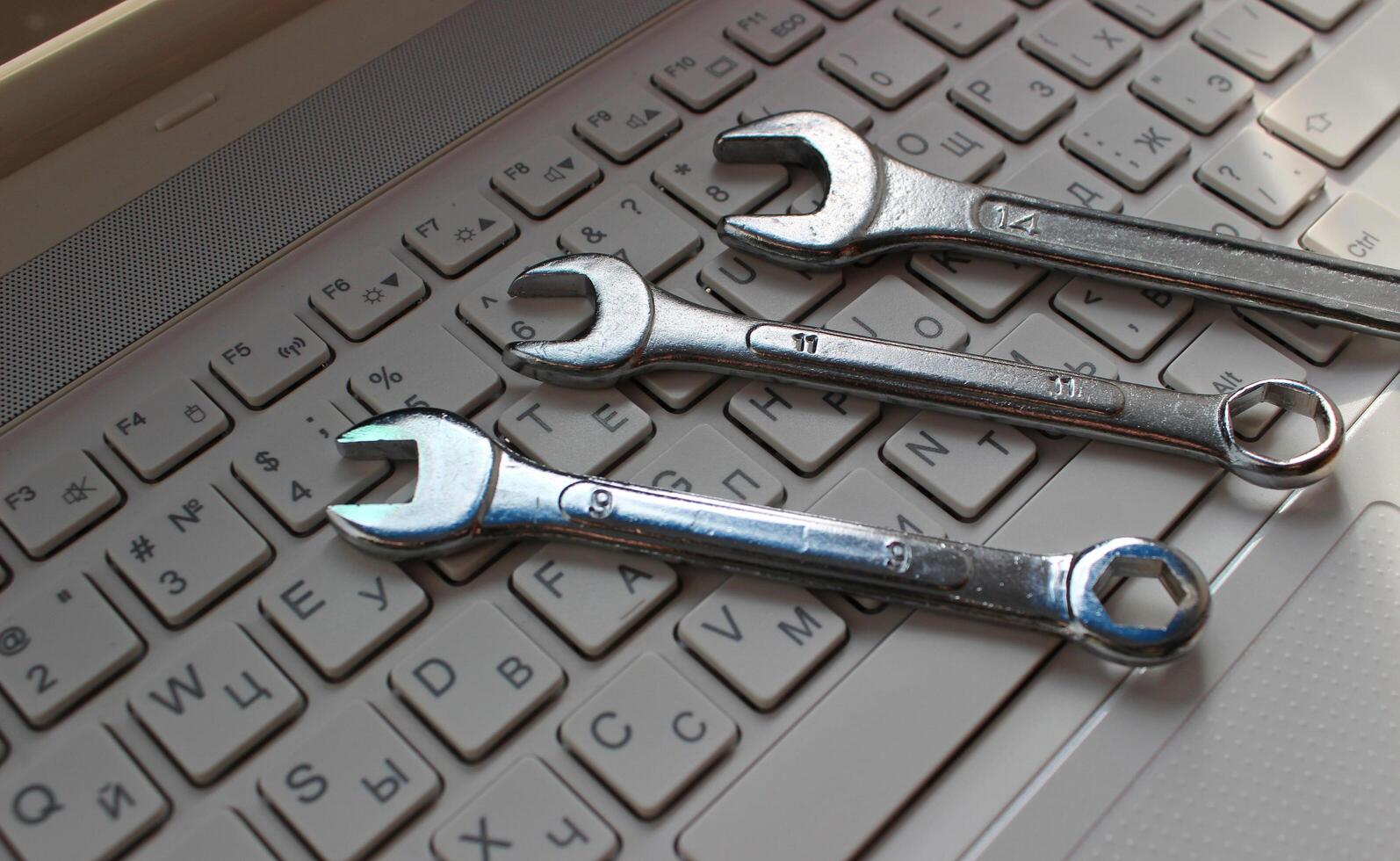 Computer Service Illustration Stock Image. Hand Wrenches On Computer Keyboard With Latin And Cyrillic Letters photo