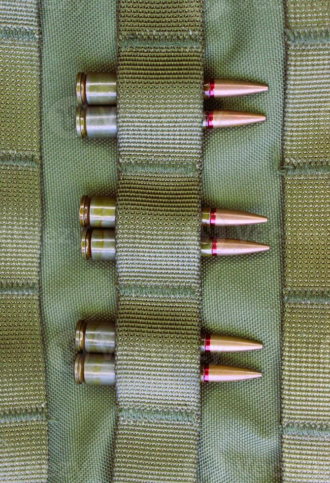 Combat cartridges are attached to tactical belts vertical stock photo for military backgrounds