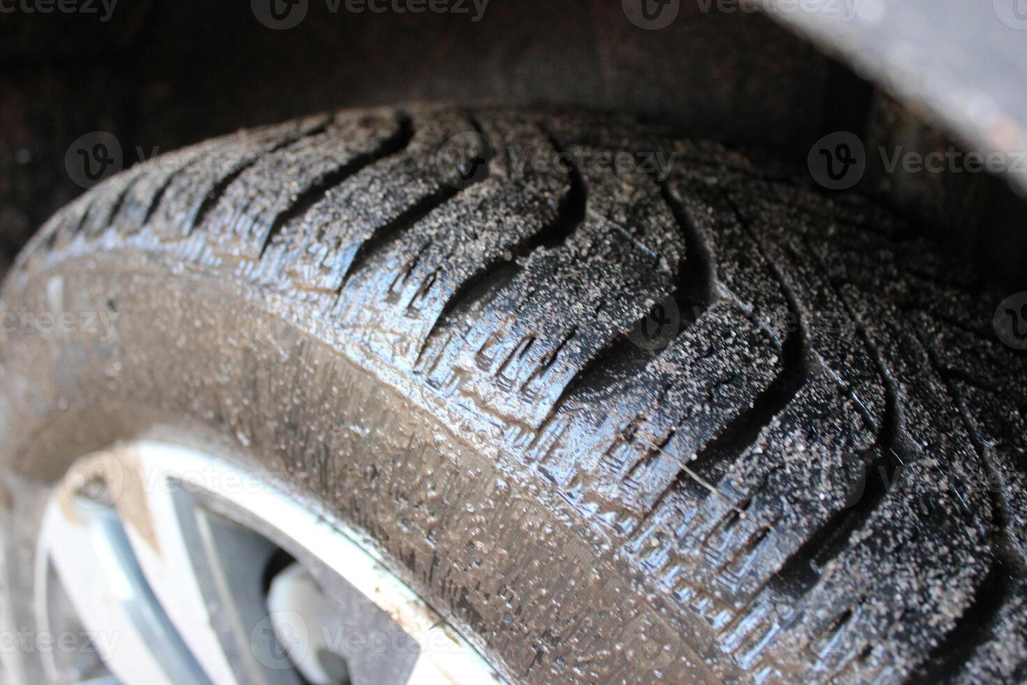 The car's all season tire is covered in mud photo