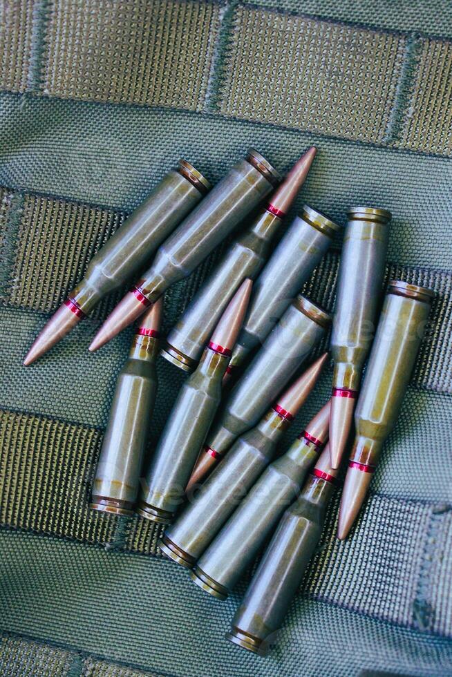 Heap Of Live Ammunition On Tactical Military Fabric With Threaded Belts photo