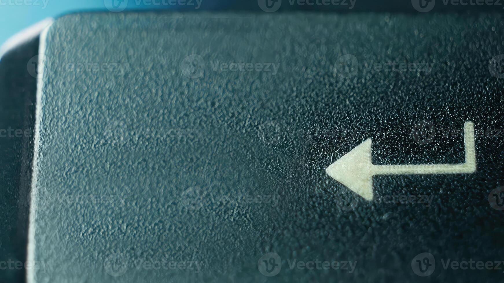 Close-Up of an Arrow Key on a Computer Keyboard Against a Soft Blue Background photo