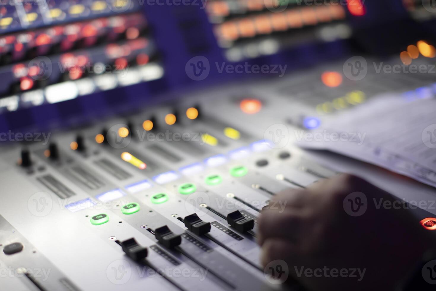 The sound engineer's hands move the sliders of the device. photo