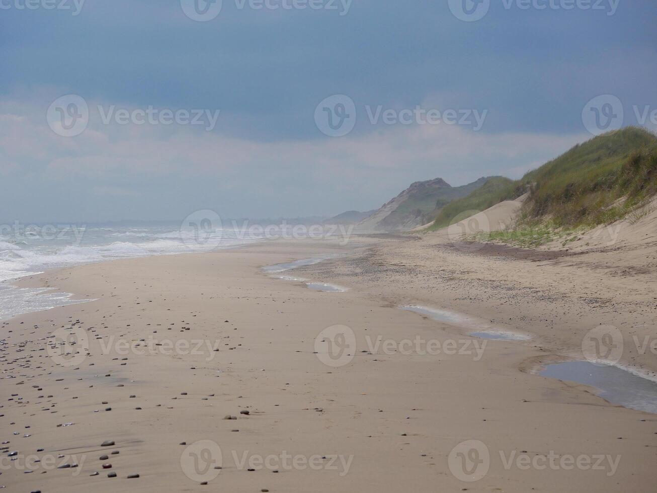 Scenic view of the sea and sand dune on the beach on a gloomy, cloudy weather, Skagen, Denmark photo