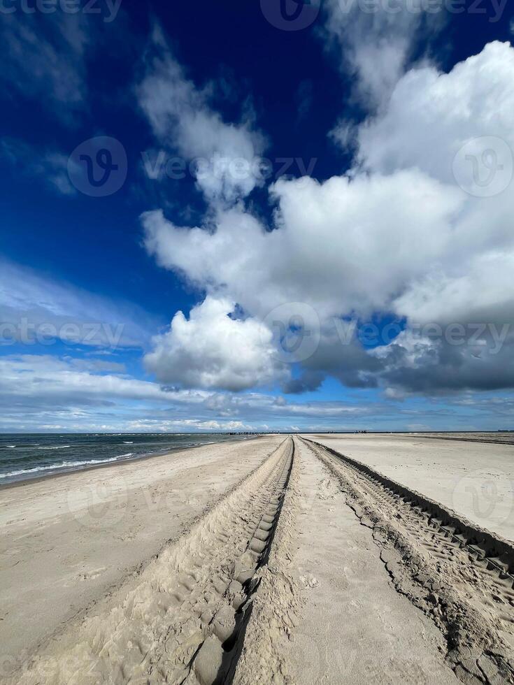 Sandormen tractor tire tracks on the sand on the cape Grenen beach in Skagen, Denmark photo