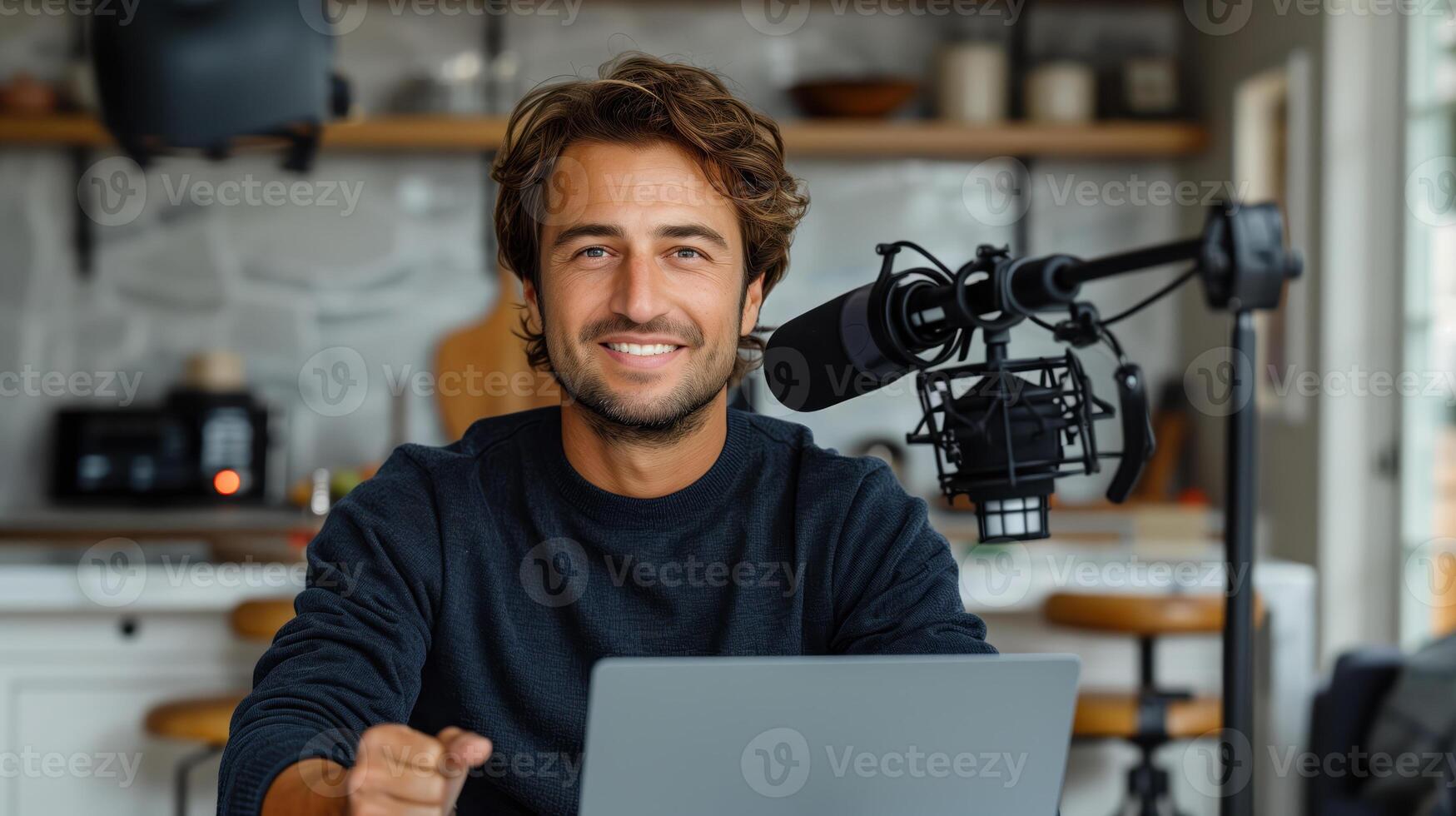 Smiling Man Recording Podcast at Home Desk with Laptop and Microphone photo