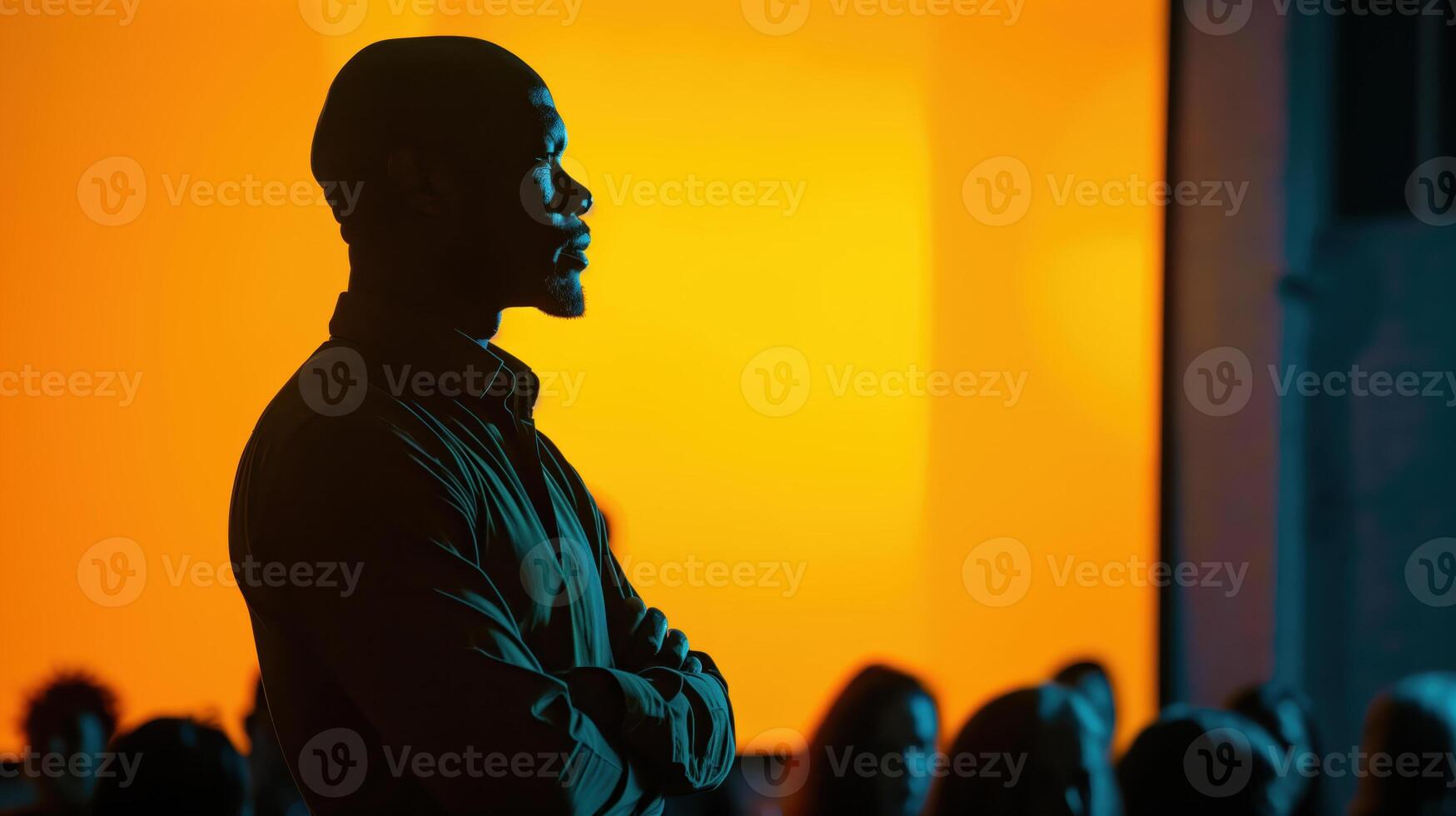 Inspirational Speaker Silhouetted Against Vibrant Orange Background During Motivational Conference photo