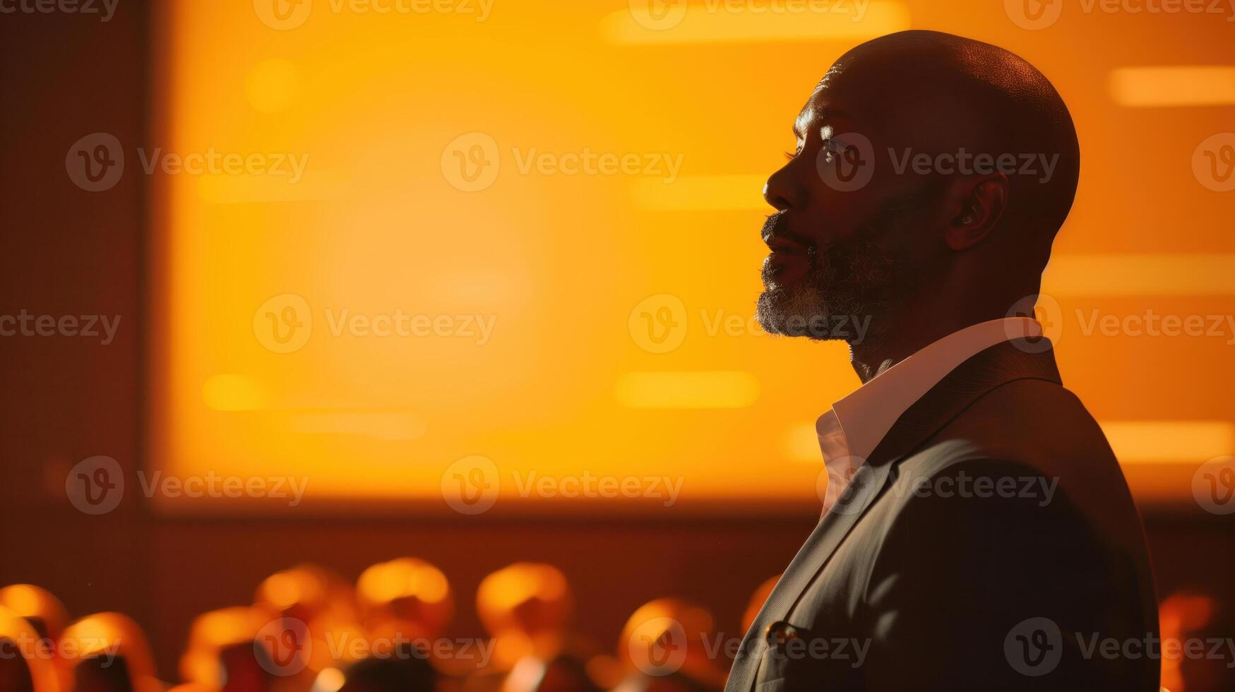 Inspirational Speaker in Profile Against Warm Orange Background During a Motivational Conference photo