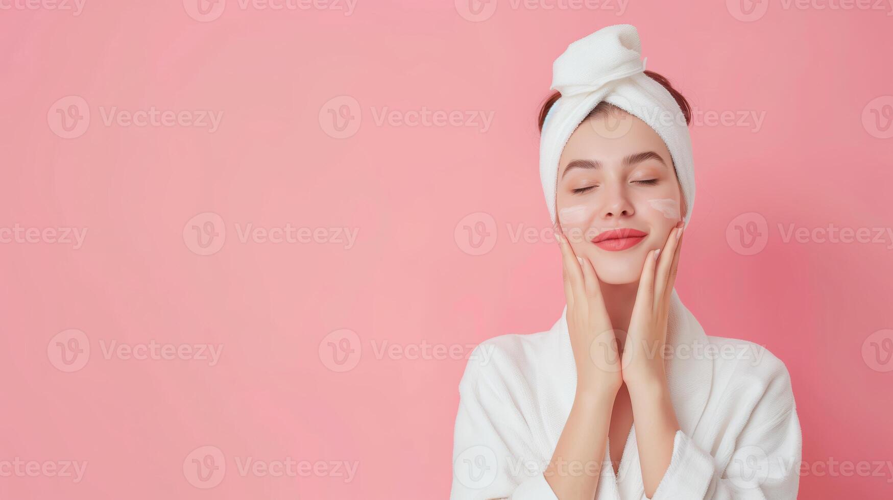 Woman Relaxing with Skin Care Routine in White Robe and Towel Turban Against a Pink Background photo