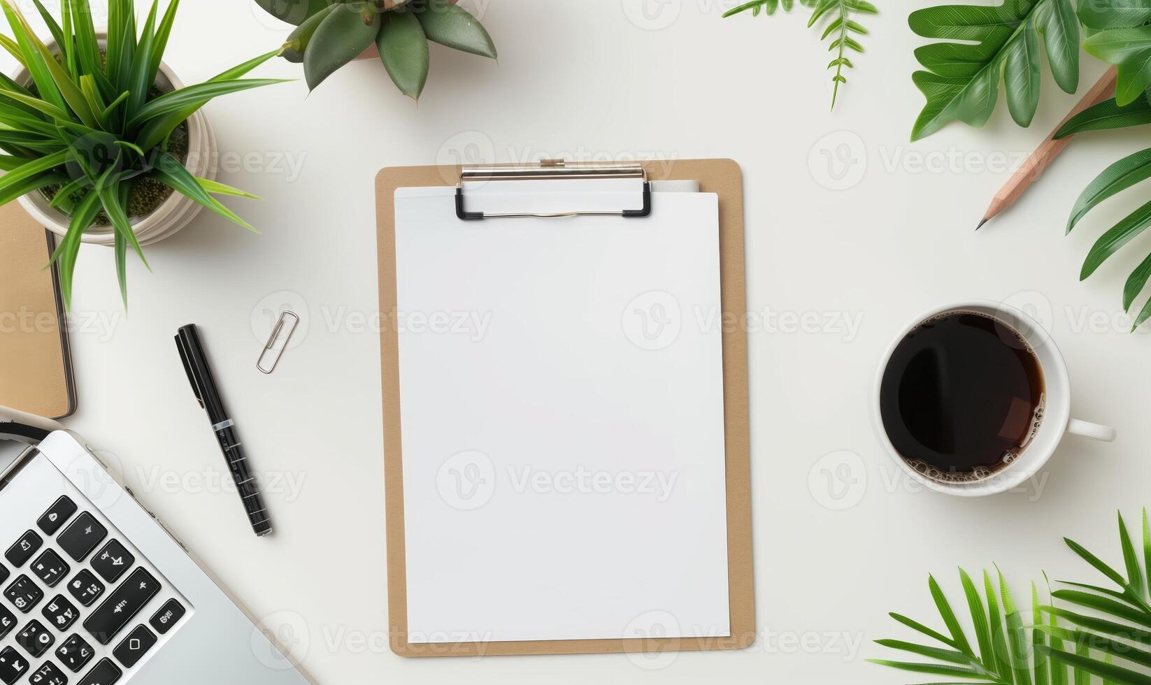Flat Lay Of Office Desk With Clipboard, Laptop, Plants, And Coffee Cup photo