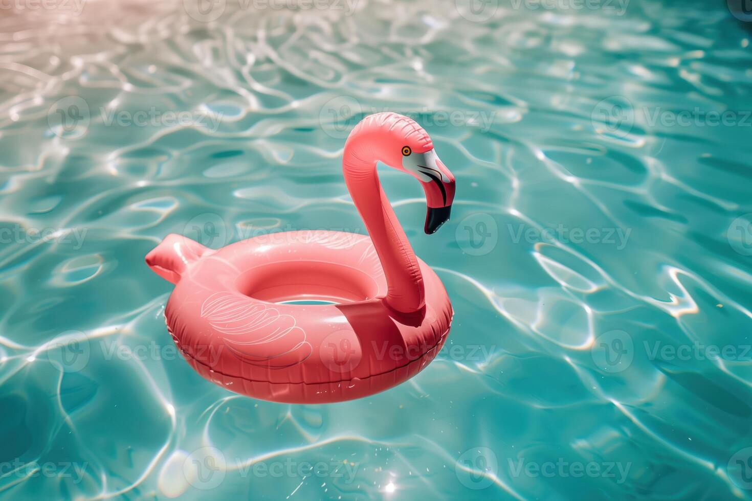 Bright Pink Inflatable Flamingo Floating in a Sparkling Outdoor Swimming Pool photo