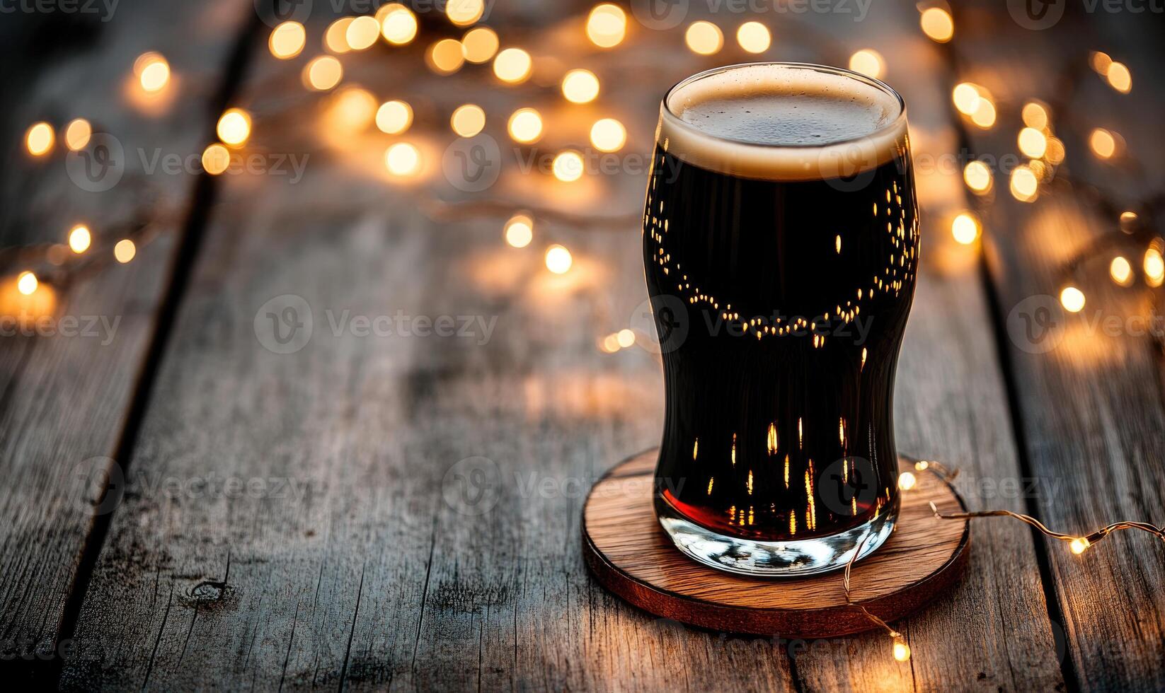Pint of dark beer on wooden coaster, encircled by warm fairy lights photo