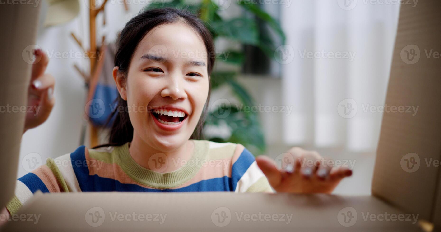 Selective focus, Happy young woman open a cardboard box to look at the items she moved from old home. Moving house and lifestyle concept. photo