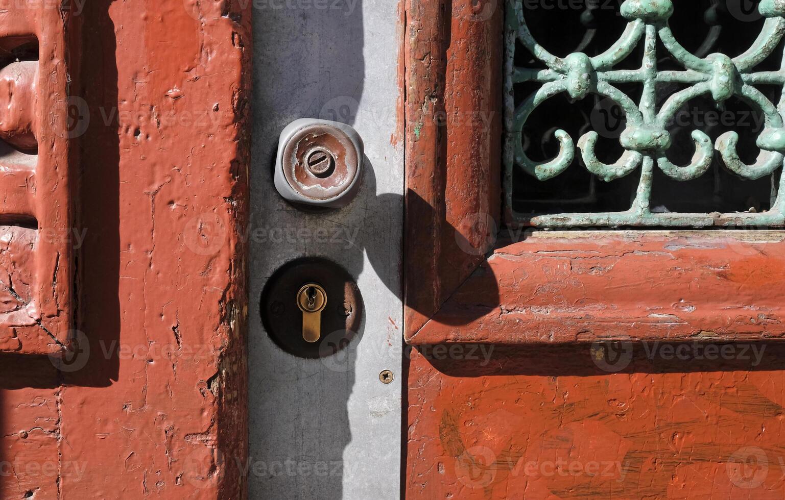 Weathered entrance with closed door, doorknob and key hole photo