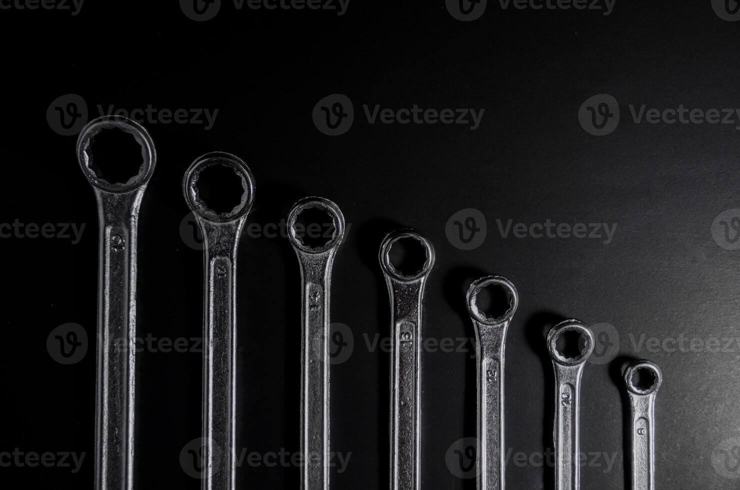 silver wrench sort by small to large on dark light on top view photo