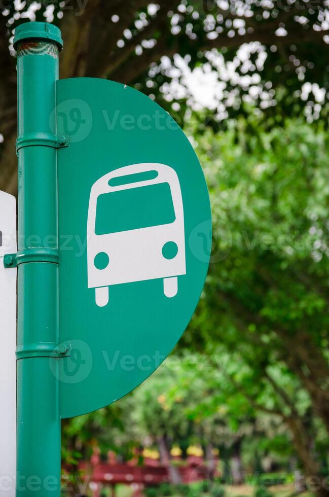 bus stop pole in green tree background photo