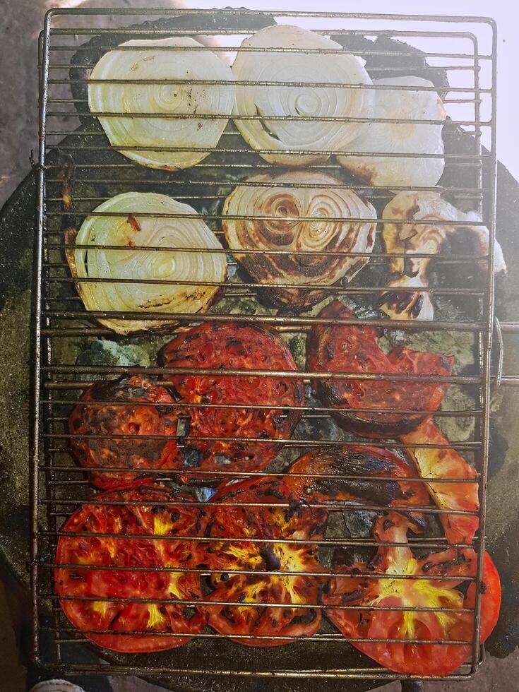 Onions and tomatoes on the grill with this vibrant of onions nd tomatoes that stimulate the barbecue photo