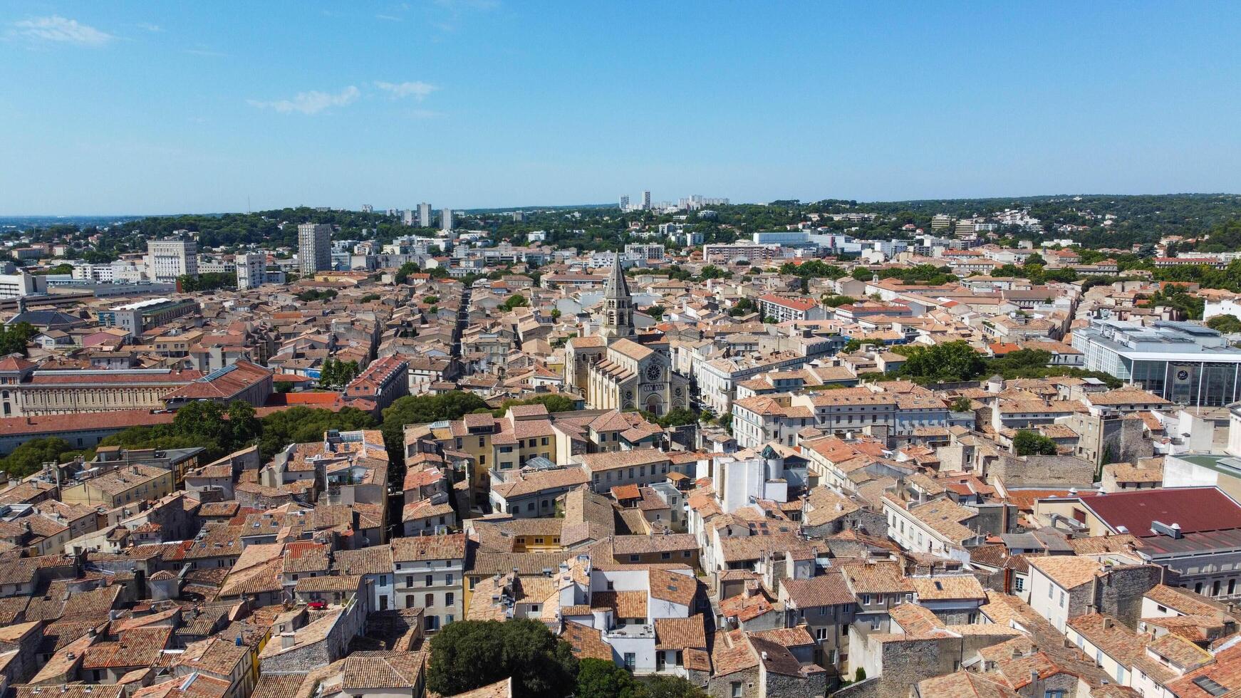 Aerial view of the French city of Nimes with the Eglise Saint-Baudile, Cathedrale Notre-Dame-et-Saint-Castor and the Roman Arena of Nimes. Famous picturesque town located in Provence, France. photo