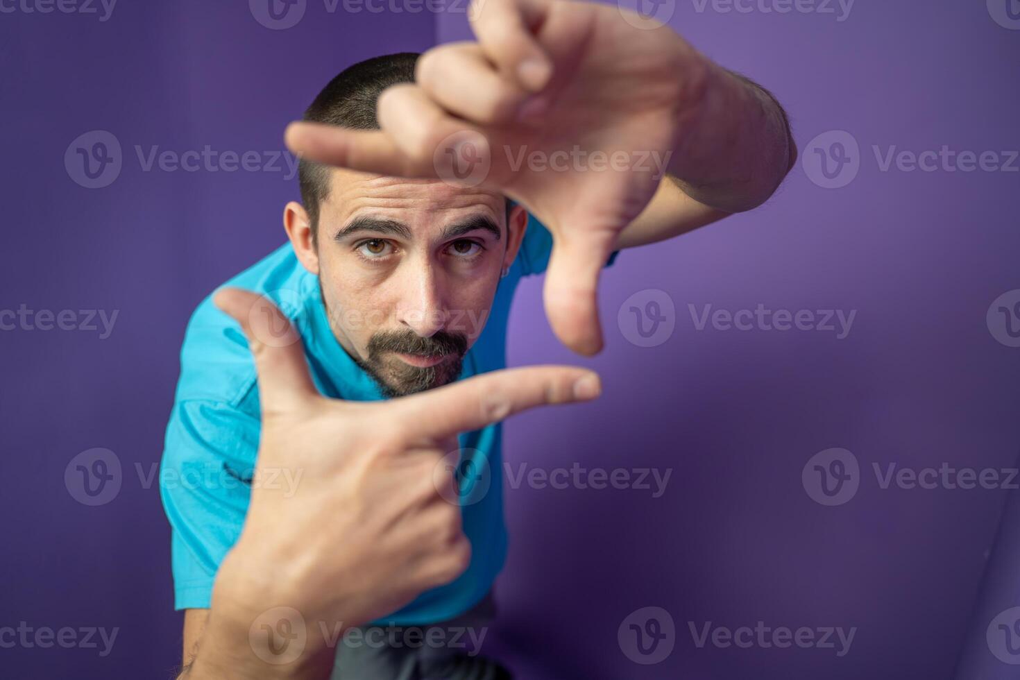 Man doing frame using hands and fingers, isolated over purple background photo
