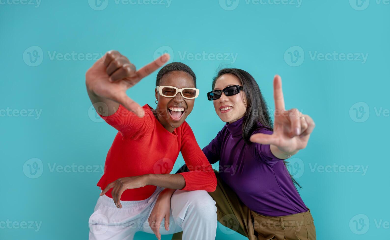 Young afro american and chinese woman over isolated background smiling making frame with hands photo