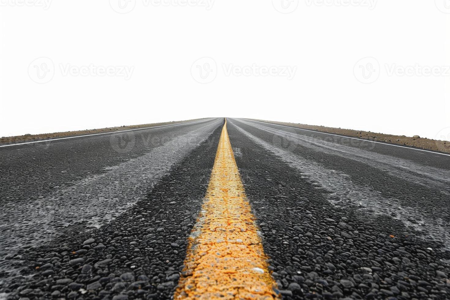 A long straight road with a yellow centerline under a bright sky photo
