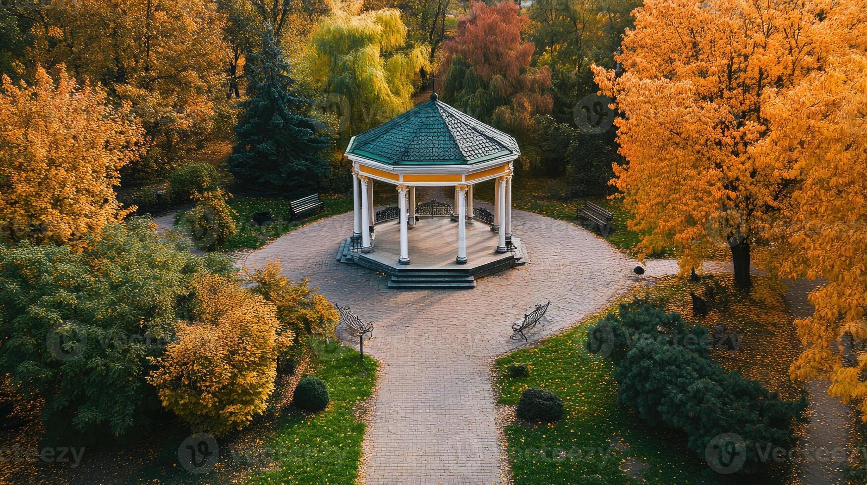 Elegant gazebo in a tranquil park surrounded by vibrant autumn foliage during a sunny afternoon photo