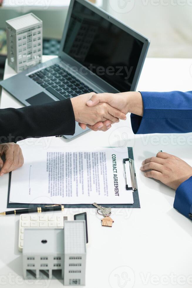 real estate agent shakes hands with customer after agreeing to sign sales contract and signing contract deliver real estate customer. concept of success in agreeing to sign real estate sales contract photo