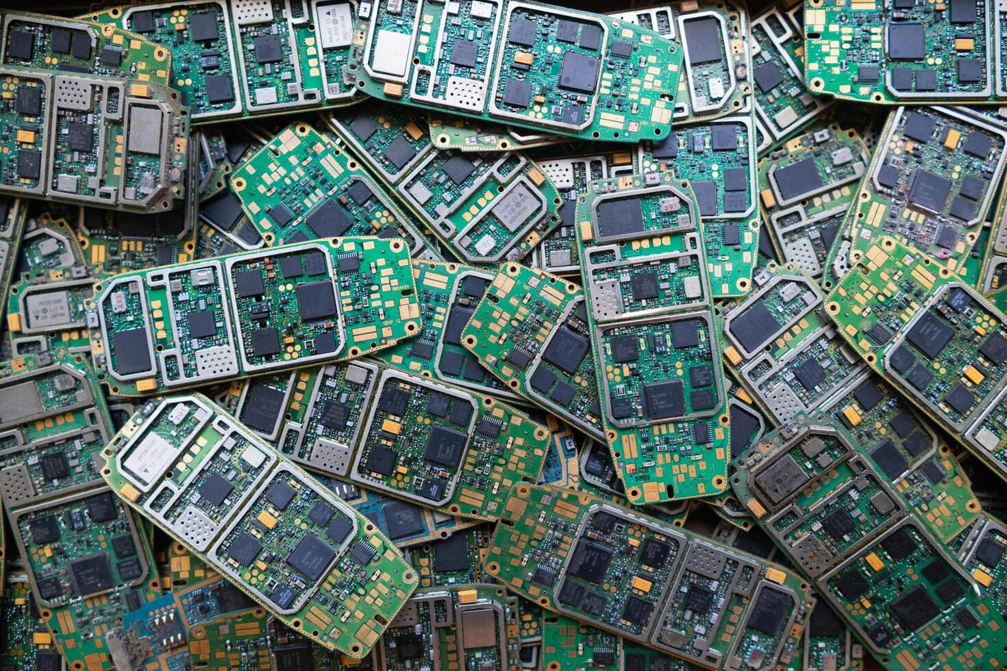 pile of electronic waste on factory floor is circuit board of mobile phone waiting to be processed extract gold to separate precious metal from electronic waste. extracting precious metal from e-waste photo