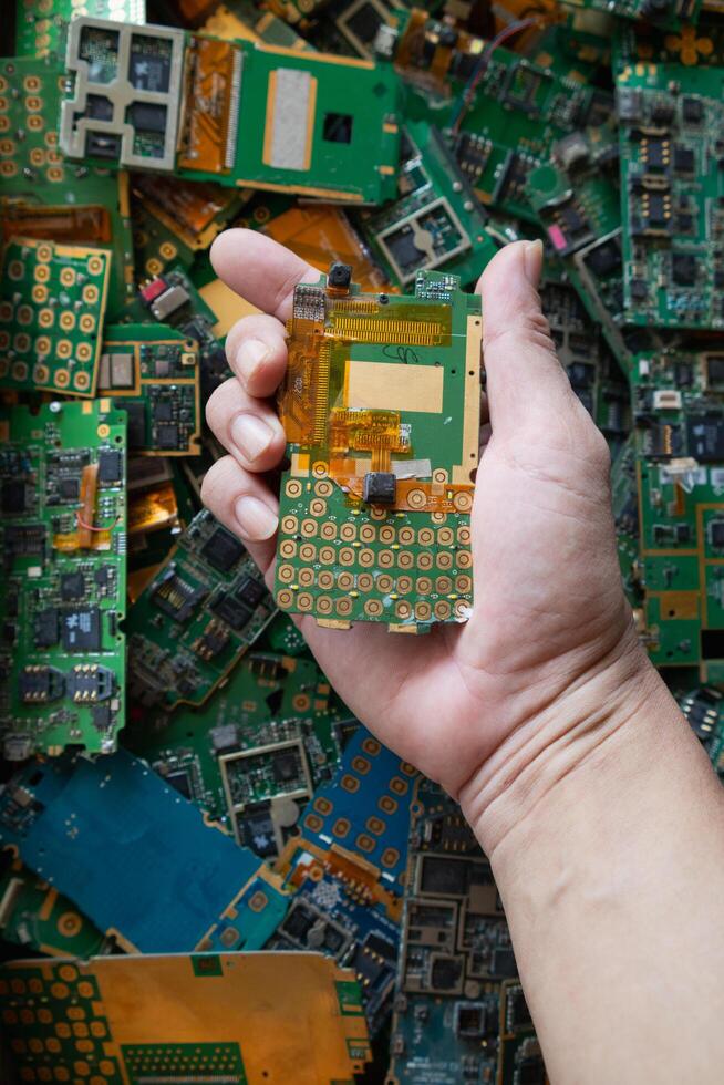 pile of electronic waste on factory floor is circuit board of mobile phone waiting to be processed extract gold to separate precious metal from electronic waste. extracting precious metal from e-waste photo