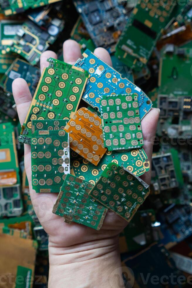 pile of electronic waste on factory floor is circuit board of mobile phone waiting to be processed extract gold to separate precious metal from electronic waste. extracting precious metal from e-waste photo