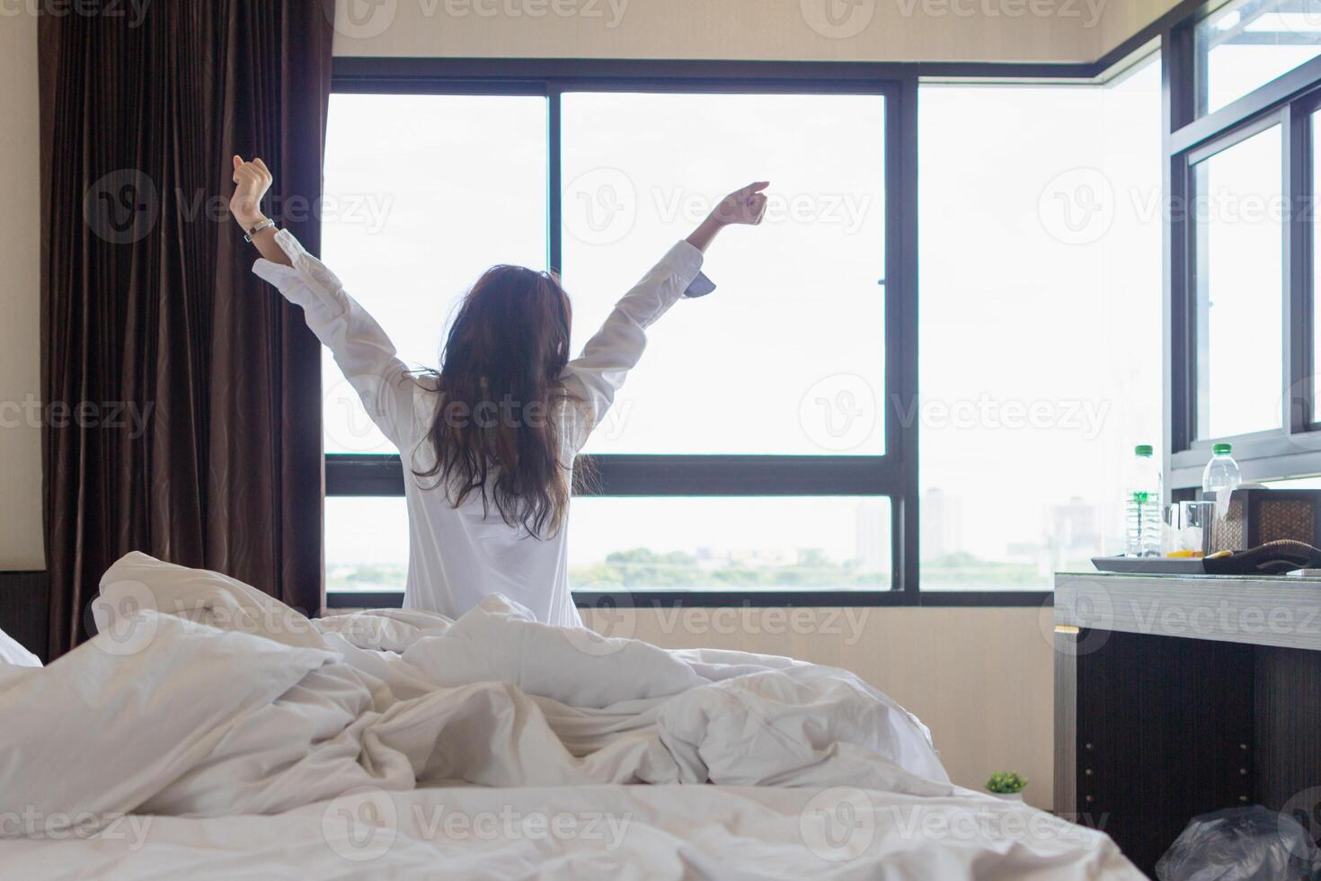 young woman wakes up in morning alone and prepares to go to work. young woman prepares to put on her clothes after waking up in morning to prepare to go on an excursion according to program. photo