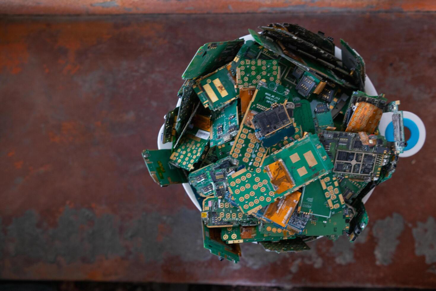 pile of electronic waste on factory floor is circuit board of mobile phone waiting to be processed extract gold to separate precious metal from electronic waste. extracting precious metal from e-waste photo