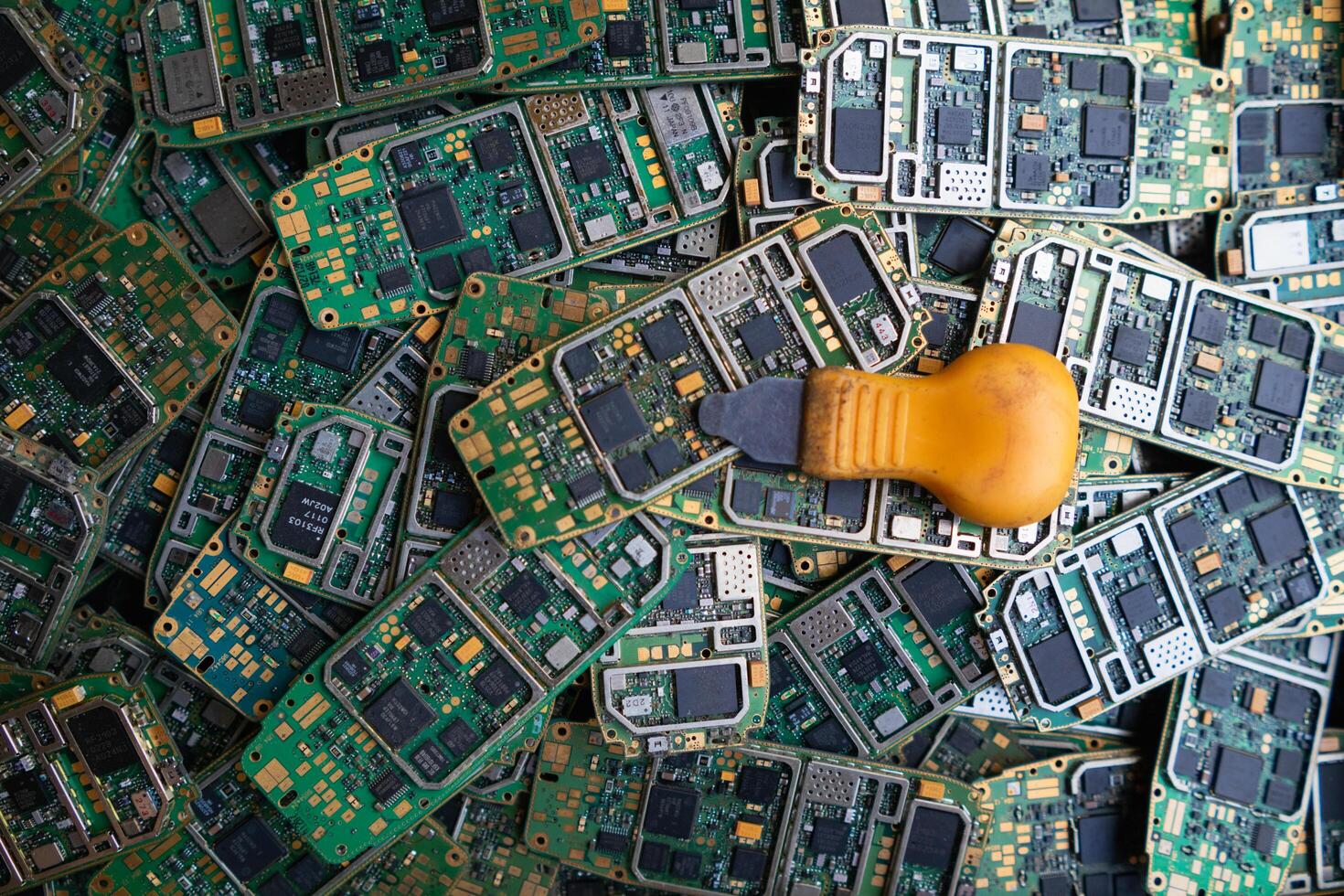pile of electronic waste on factory floor is circuit board of mobile phone waiting to be processed extract gold to separate precious metal from electronic waste. extracting precious metal from e-waste photo