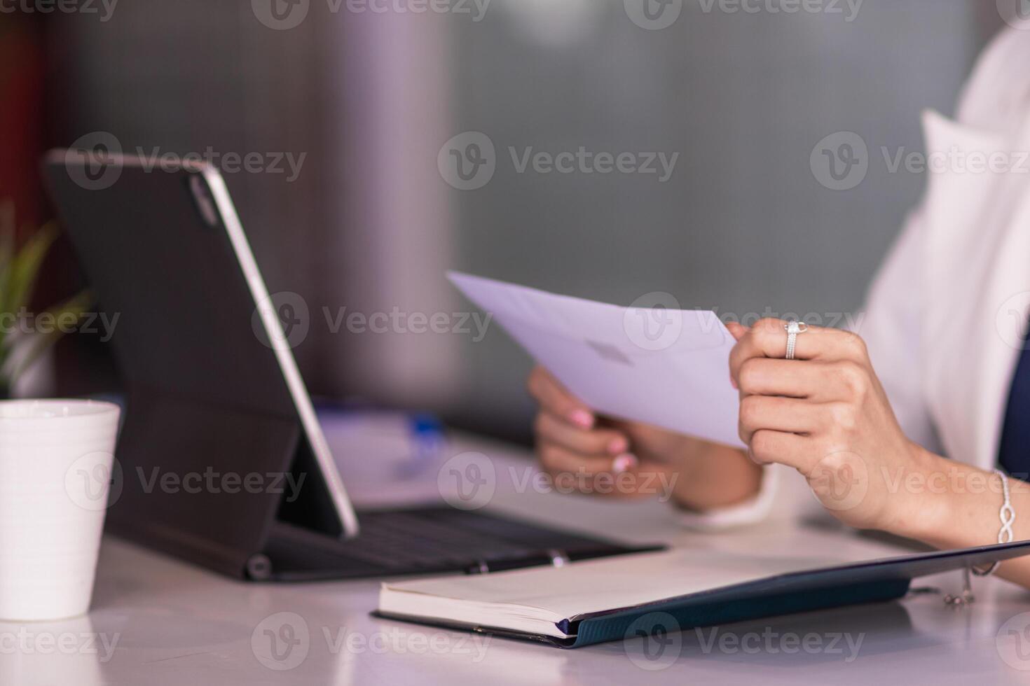 A female employee holds a white envelope to give to her manager after she decides to quit to pursue her own business. The concept of resigning from a full-time employee to start a private business photo