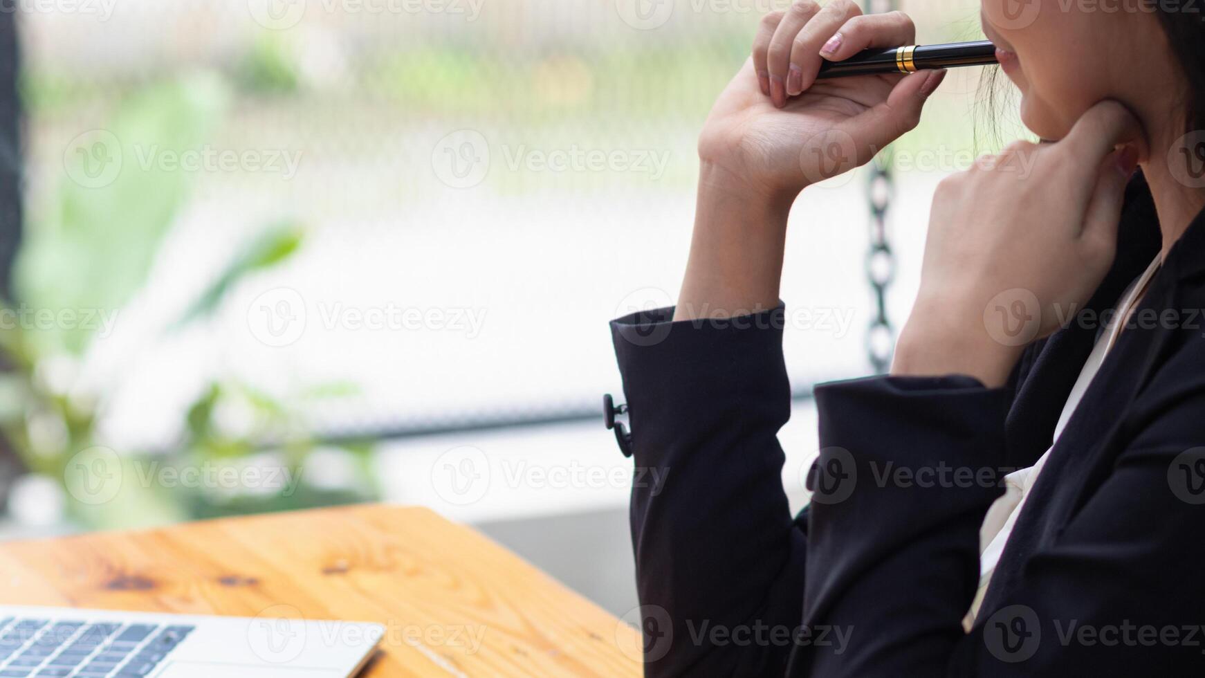 young businesswoman is reviewing results of corporate network via laptops and the Internet in order to prepare documents for meetings to give investors confidence in doing business. photo