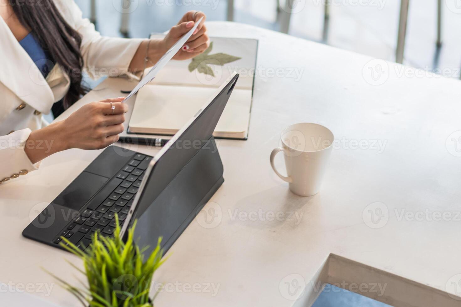 A female employee holds a white envelope to give to her manager after she decides to quit to pursue her own business. The concept of resigning from a full-time employee to start a private business photo