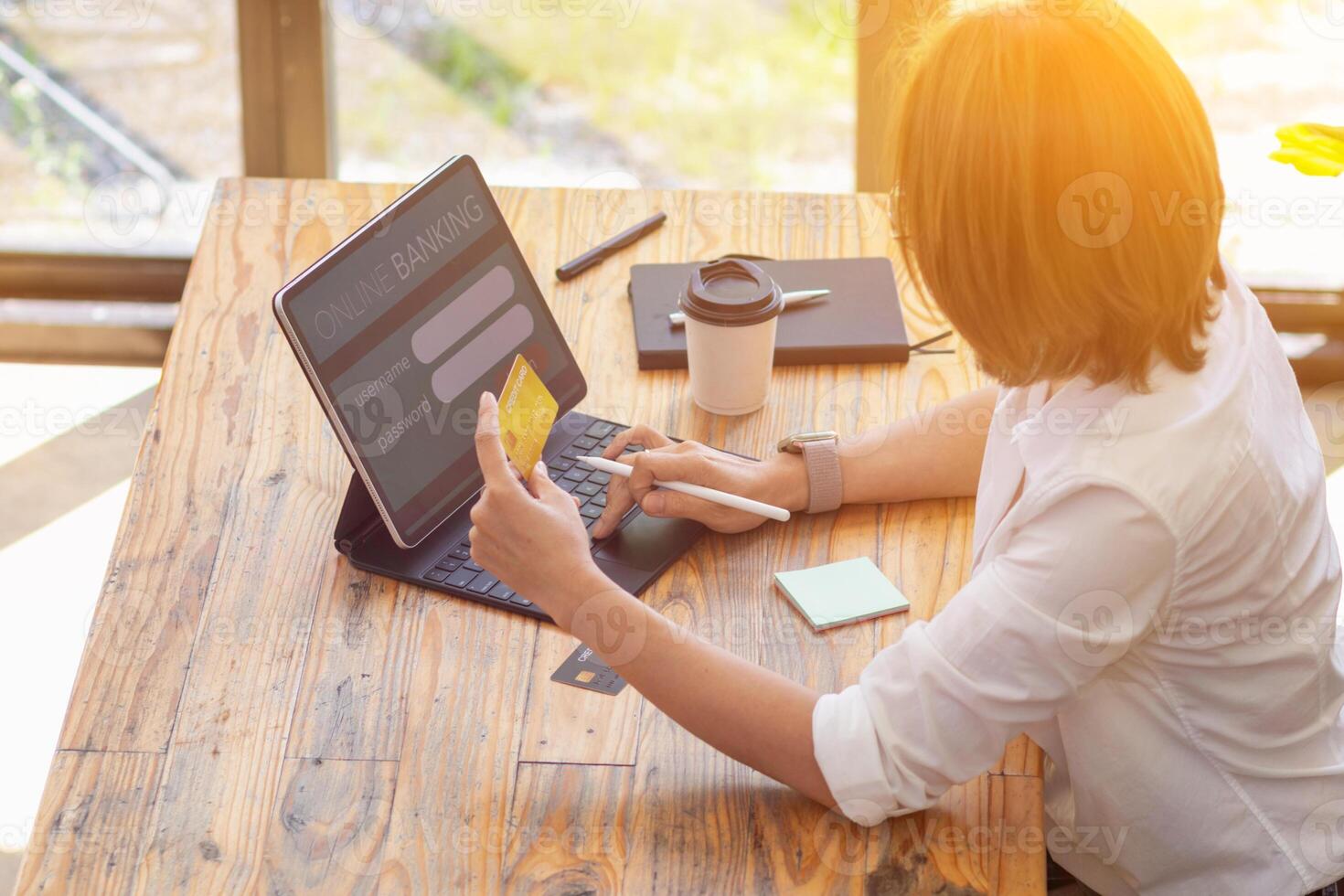 A businesswoman is using a credit card to pay for online shopping during breaks to get the items she wants from online stores without having to travel on her own and at her convenience. photo