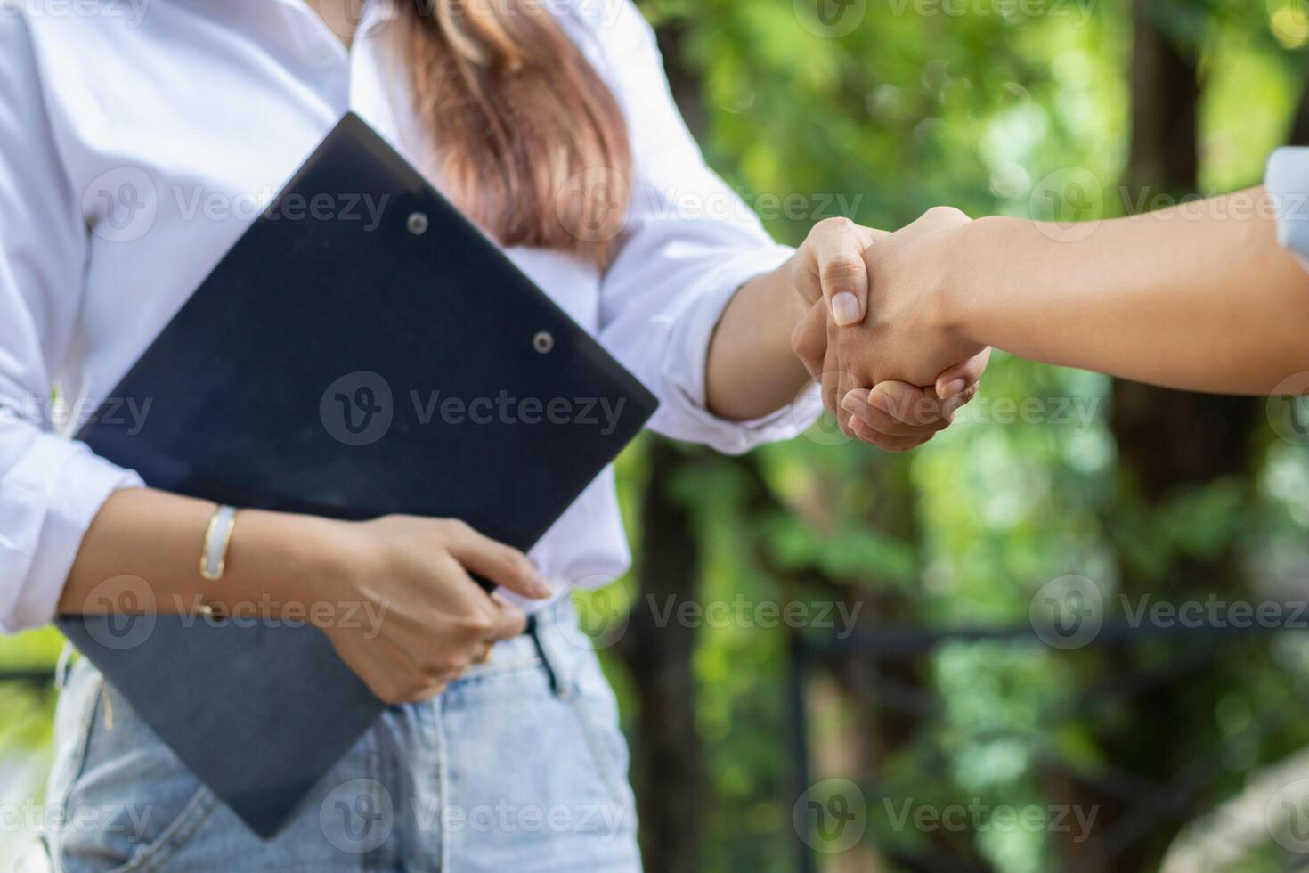 The young businesswoman shook hands with legal advisers after drawing up a contract for investors to sign and to ensure legitimacy. Business idea with a legal advisor to consult for accuracy. photo