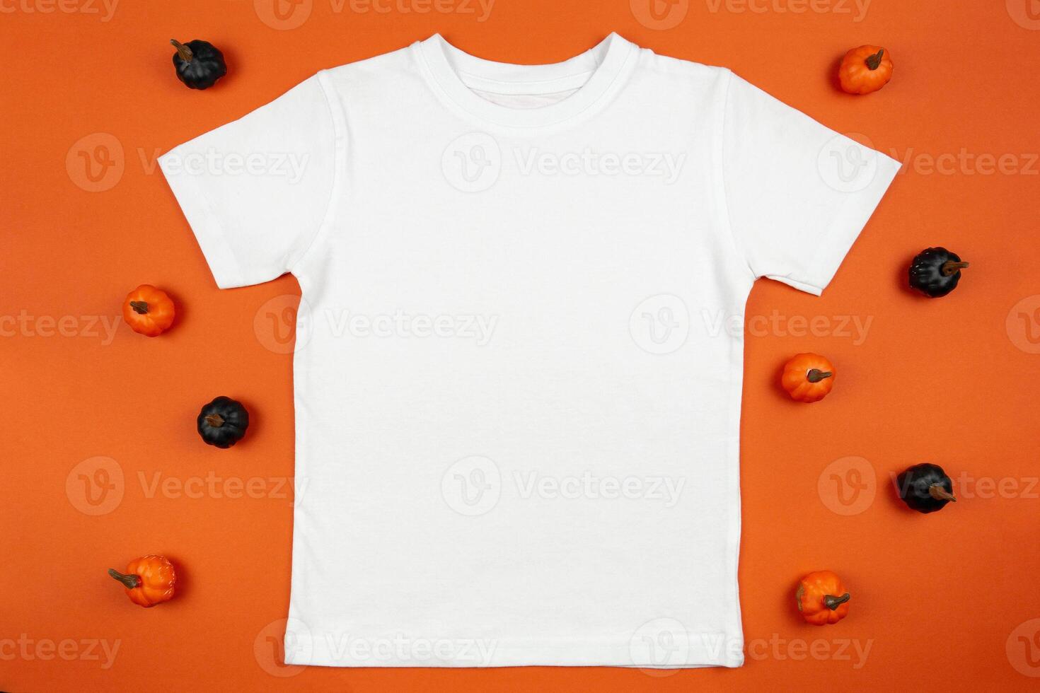 White womens cotton t-shirt halloween mockup with pumpkins on orange background. Design t shirt template, print presentation mock up. Top view flat lay. photo