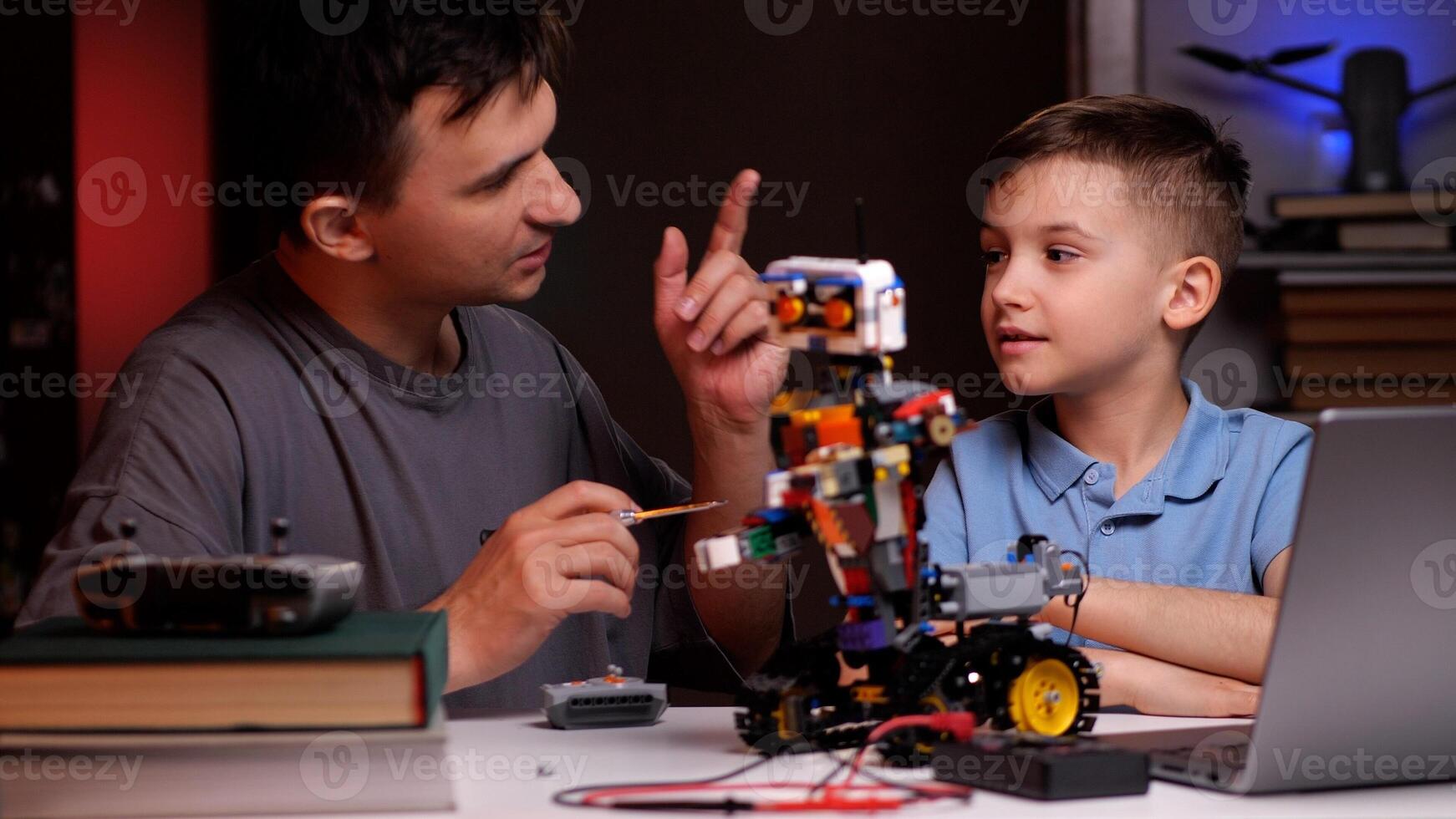 Father and son building robot and developing robotics skills photo