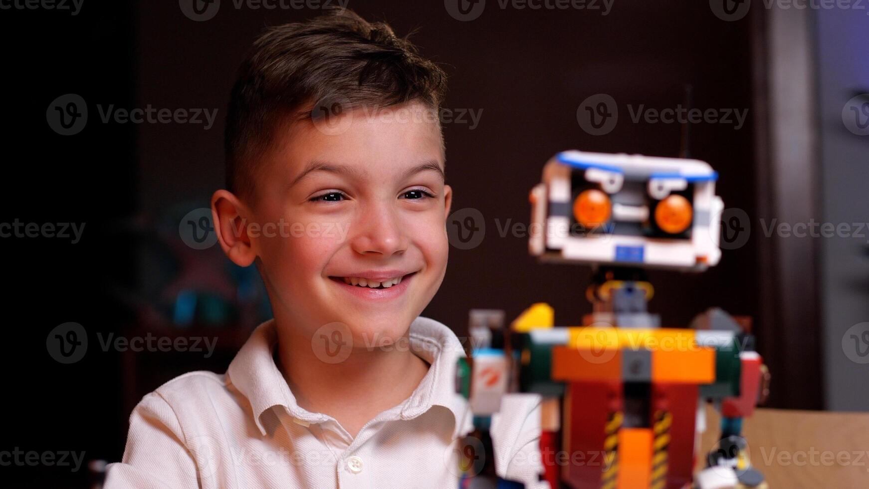 Happy boy smiling and playing with robotics at home photo