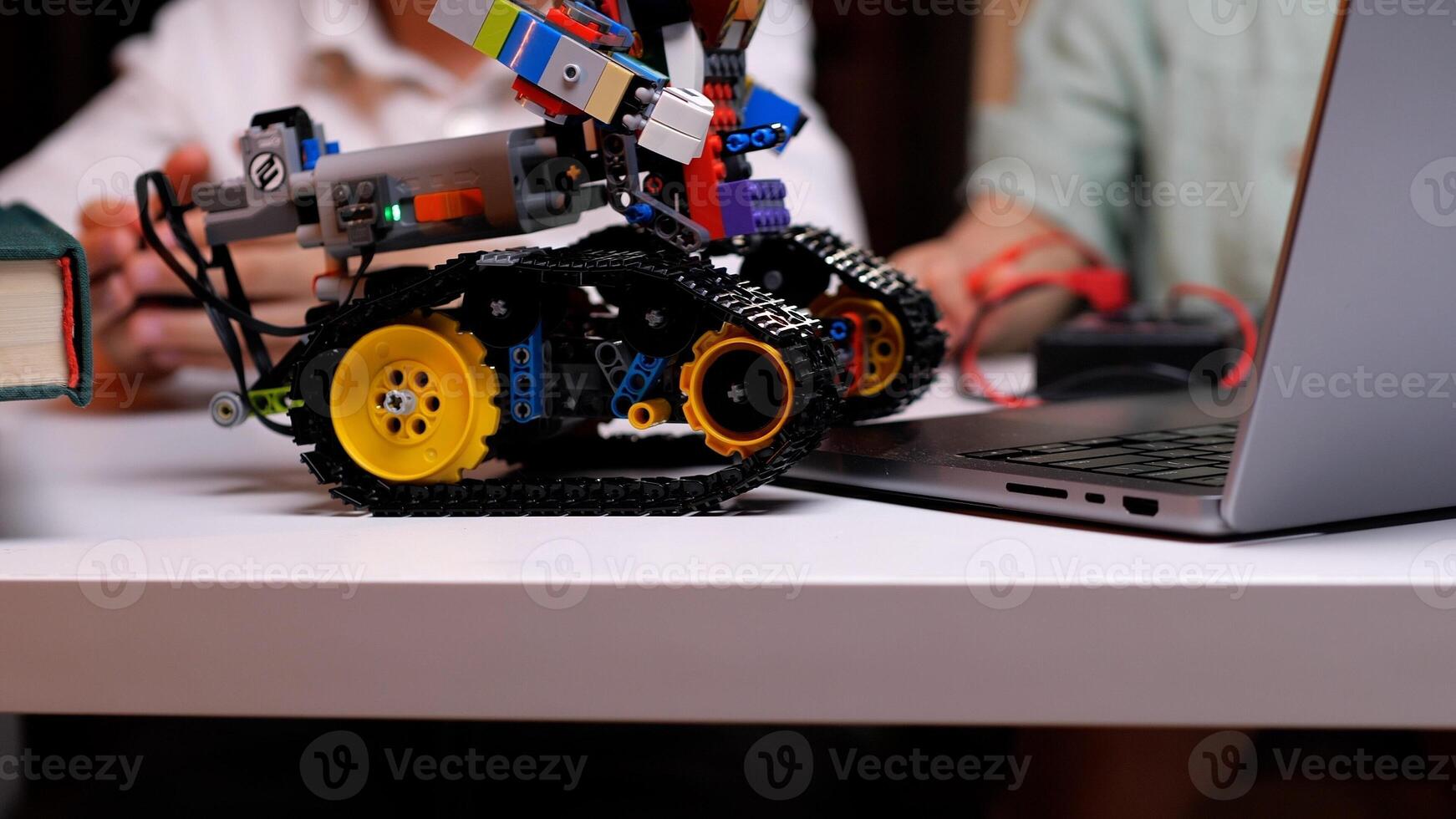 Robotics engineer programming robot vehicle using laptop computer photo