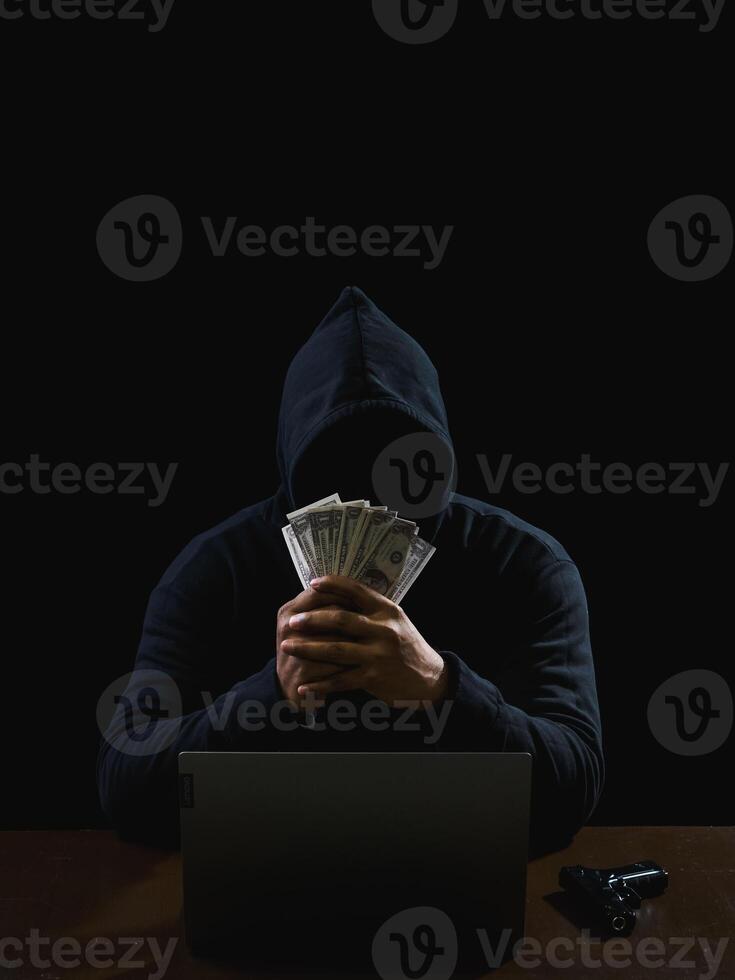 Portrait hacker spy man one person in black hoodie sitting on table looking computer laptop used login password attack security to data digital internet network system night dark background copy space photo