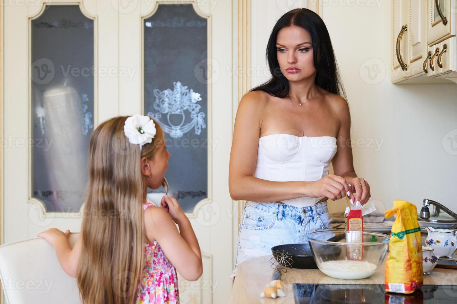 Mother and Daughter Cooking Together in Bright Kitchen While Preparing a Delicious Meal photo