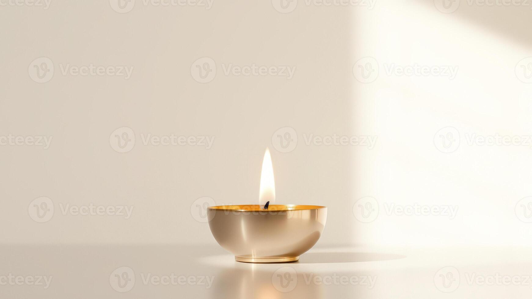 A single lit candle in a golden bowl photo
