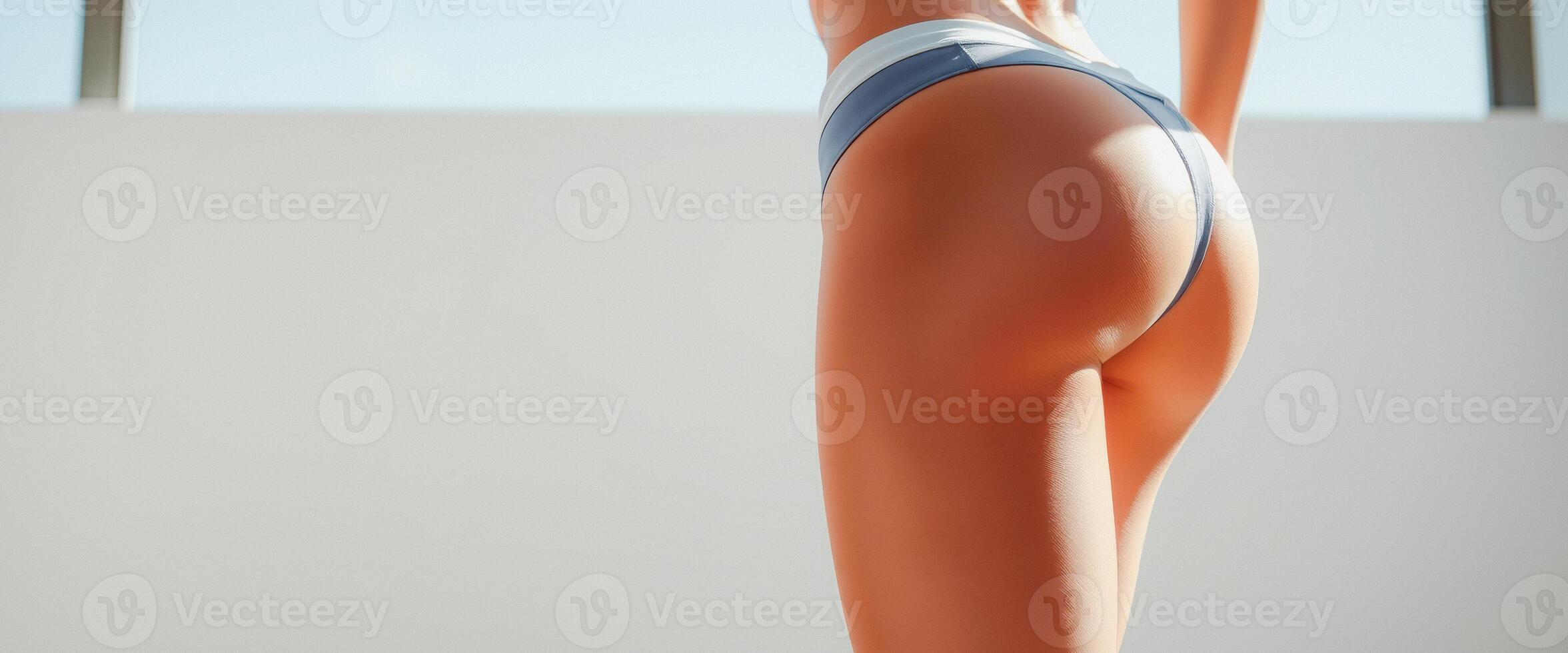 Woman in White and Blue Bikini Bottom Standing in Front of a Window photo