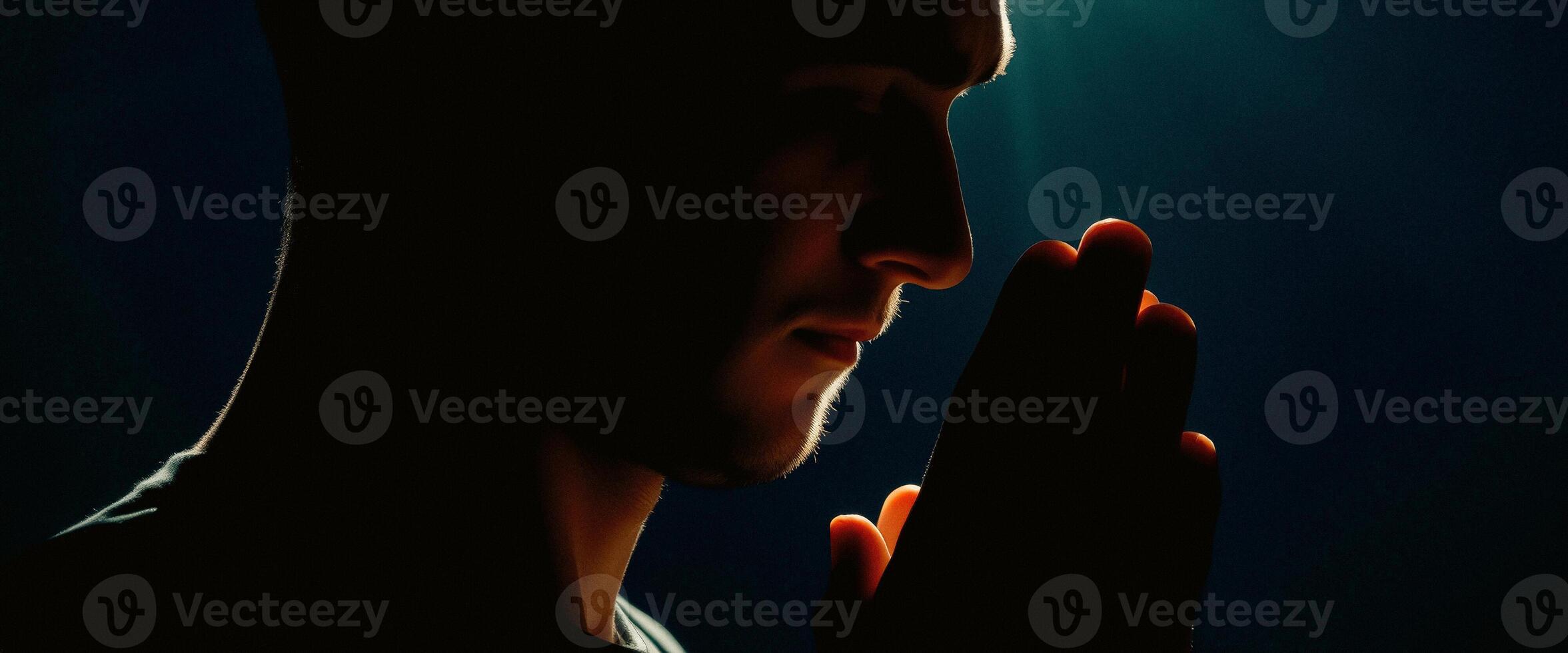 Silhouette of a Man Praying with Hands Together photo