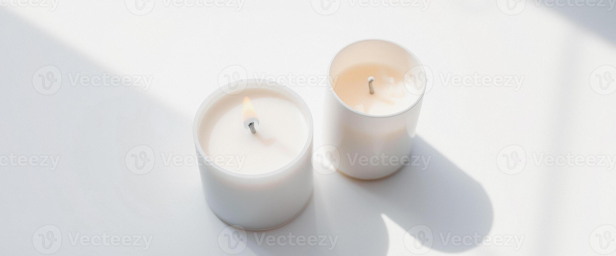 White Candles with One Burning on a White Surface photo