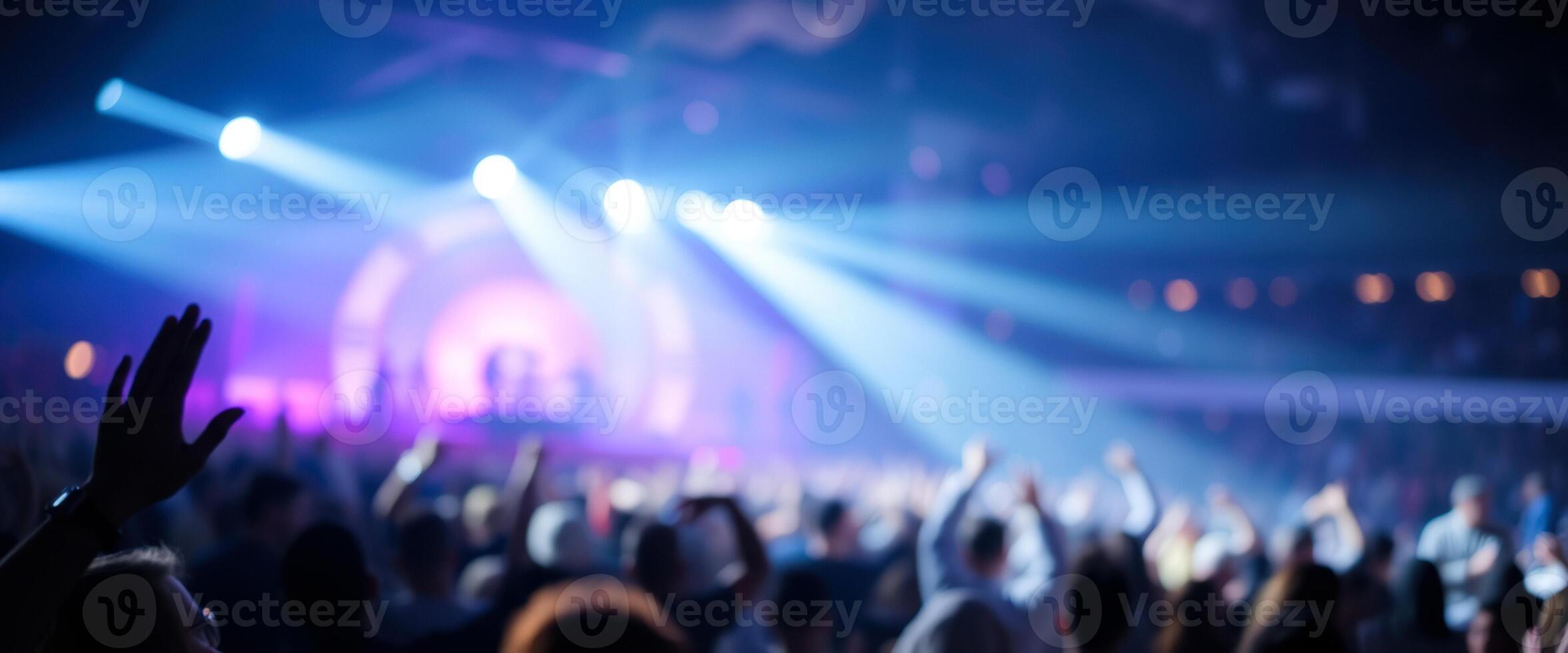 Blurred crowd at a concert with stage lights photo