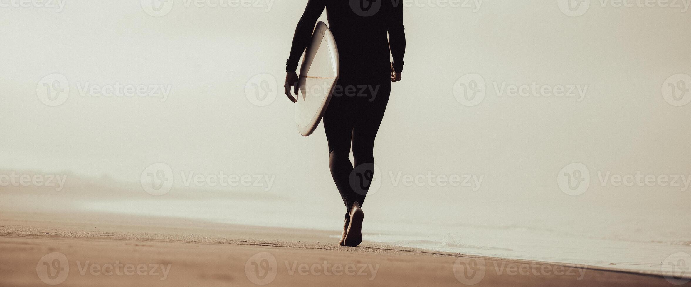 Surfer walking on the beach with surfboard photo